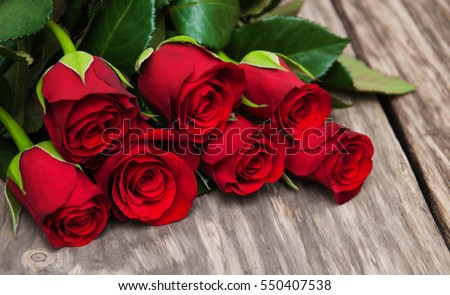 Red roses  on a old wooden table Royalty-Free Stock Photo #550407538