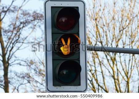 At a traffic light, symbols are visible through their light.