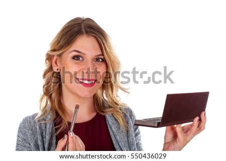 Picture of a pretty young lady while doing her make-up