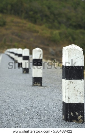 Black and white road barrier with blur background, selective focus at first barrier.