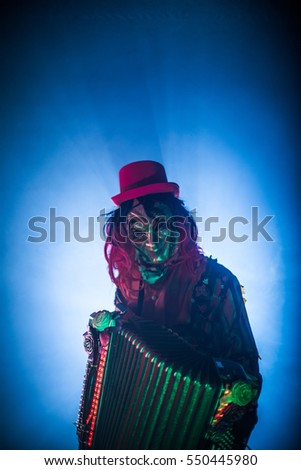 Venetian masquerade accordion player in the smoke and darkness.