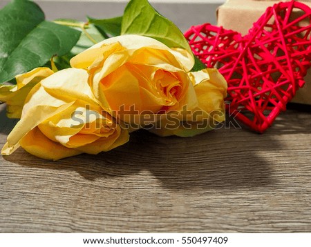 yellow and white roses and Valentine's Day hearts on wooden background. Top view with copy space.