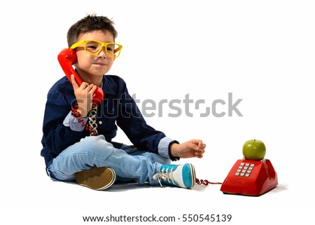 Studio shot of cute boy talking on old telephone isolated against white background