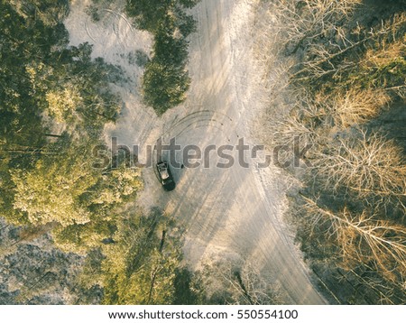 aerial view of snowy forest in sunny winter day with country road. drone photography - vintage effect