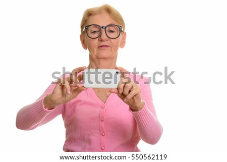Senior nerd woman taking picture with mobile phone isolated against white background