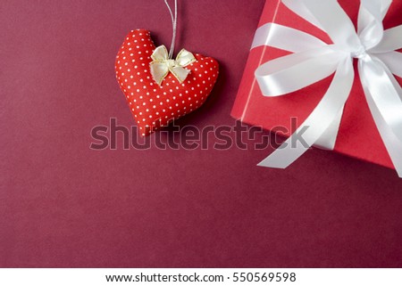 Red fabric heart and gift box on paper background