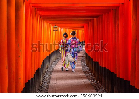 Women in traditional japanese kimonos walking at Fushimi Inari Shrine in Kyoto, Japan Royalty-Free Stock Photo #550609591