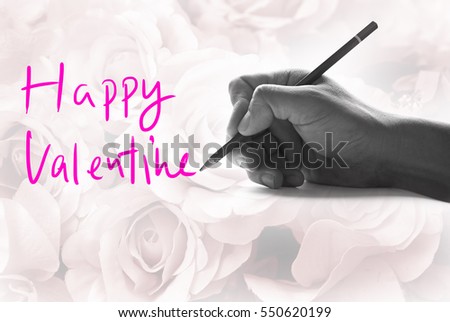 Hand holding a pencil on a vintage rose background, writing for word " Happy Valentine "