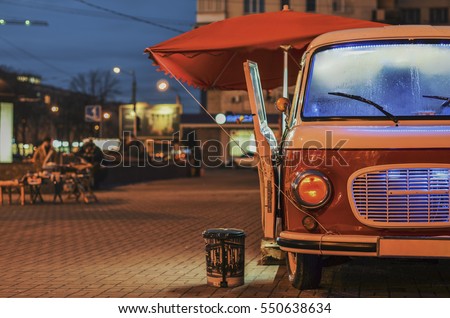 Food Truck on wheels in night street Royalty-Free Stock Photo #550638634