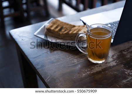 Lemon Tea and laptop for business, relax concept. Selective focus on drink, bread or laptop