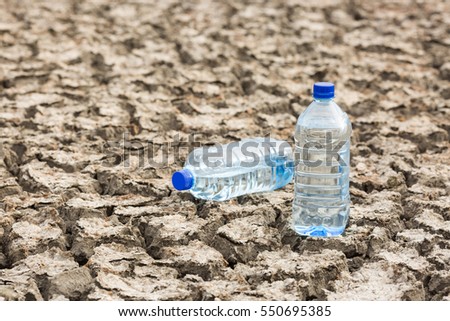 Bottle with water on the dried ground.