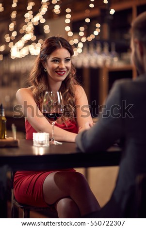 Seductive beautiful lady in bar with boyfriend in touch