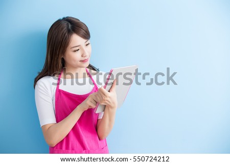 beauty housewife take tablet and smile isolated on blue background, asian