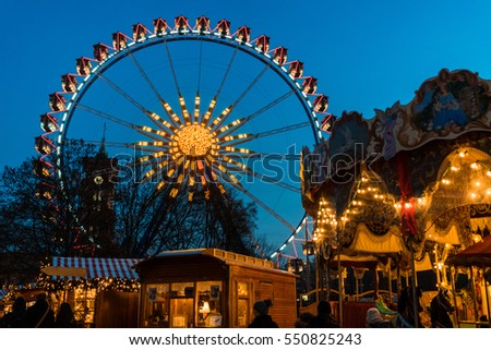 Night shot of a winter carnival lights with a ferris wheel and a carousel. Beautiful festive fun fair. Royalty-Free Stock Photo #550825243
