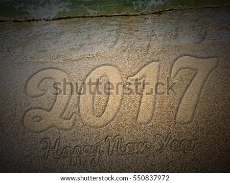 New Year 2017 is coming concept - inscription 2016 and 2017 on a beach sand, the wave is almost covering the digits 2016 Royalty-Free Stock Photo #550837972