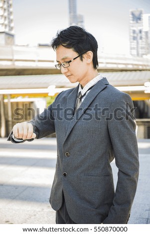 Casual new age business man looking watch,The Man starts a business hopes and watch on hand  in Downtown