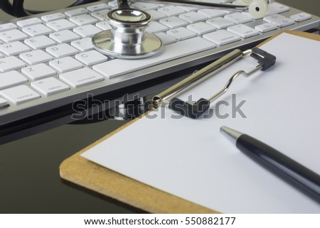 Stethoscope with clipboard, keyboard and pen on doctor worplace