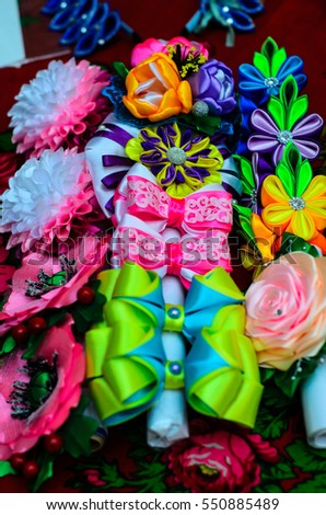 Different multicolored artificial flowers and big bows