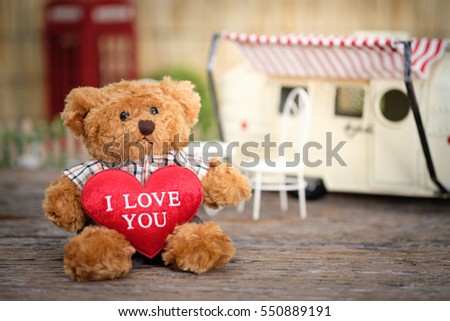 Teddy Bear holding a heart-shape pillow in valentine concept with space for write, AF point selection and blur, Vintage tone picture.