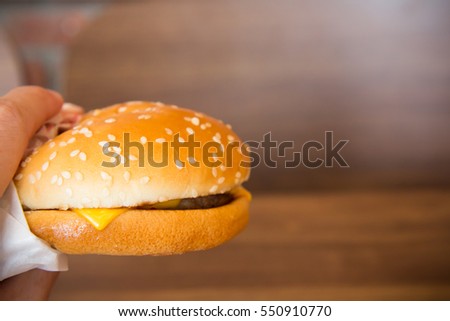 left asian man hand holding the beef cheese burger