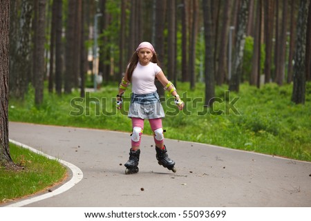 Girl riding rollerblades on skating track in a park