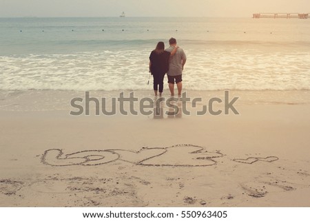 Love word written and Happy couple enjoying on the sand beach, Love Story Concept