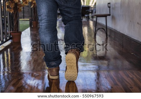 Hipster man with fashion brown leather boots on floor