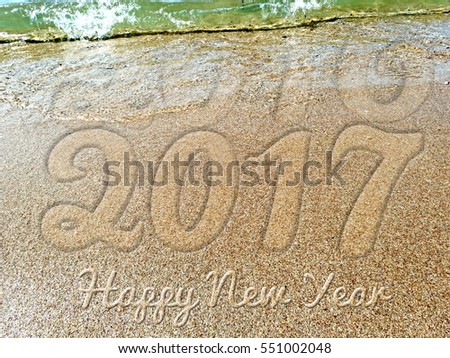 New Year 2017 is coming concept - inscription 2016 and 2017 on a beach sand, the wave is almost covering the digits 2016 Royalty-Free Stock Photo #551002048