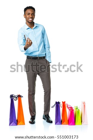 Happy african american man with shopping bags  and holding credit card on white background. Christmas and holidays concept