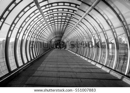 Black and white image showing Vision or concept of Pedestrian bridge during evening sunset of summer in canary wharf of London