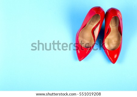 A picture of different shoes, Shot of several types of shoes, Several designs of  women shoes. Leather Shoe. Pile of various female shoes on on  light blue background. Copy space for text.