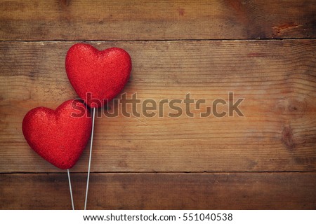 Valentines day concept. Couple of red glitter hearts on wooden background. Flat lay composition