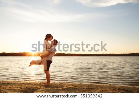 Sea travel, happy couple hugging on sea side near hot summer water of ocean. Honeymoon picture with copy space