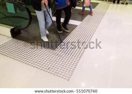 Tactile paving path for the blind  and vision impaired handicap entrance exit of escalator in Hong Kong