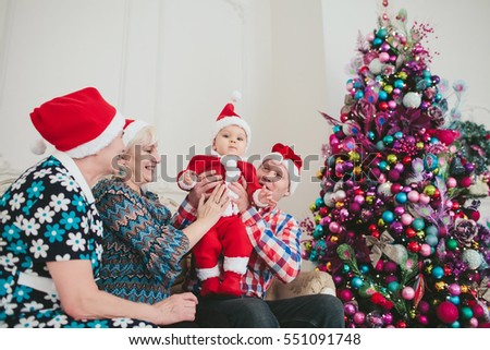 grandmothers and grandfather with a baby in a Christmas tree