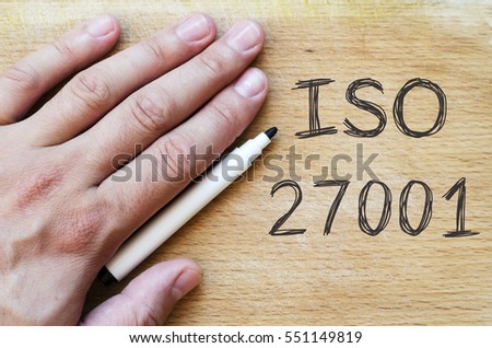 Human hand over wooden background and iso 27001 text concept