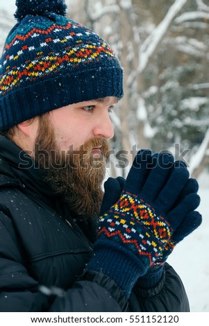 The man with a beard in winter on a street