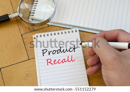 Human hand over wooden background and product recall text concept