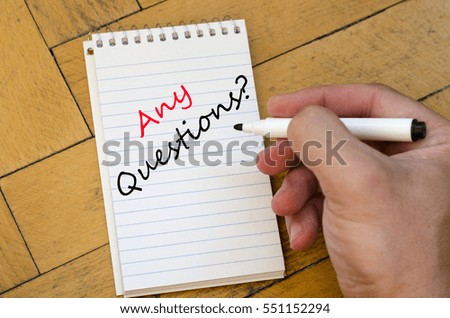 Human hand over wooden background and any questions text concept