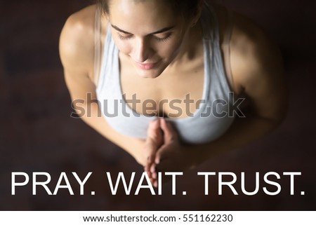 Close up portrait of beautiful young happy fit woman doing yoga or pilates exercise. Fitness motivation quote with motivational text "Pray. Wait. Trust". Healthy concept. Tadasana pose with Namaste