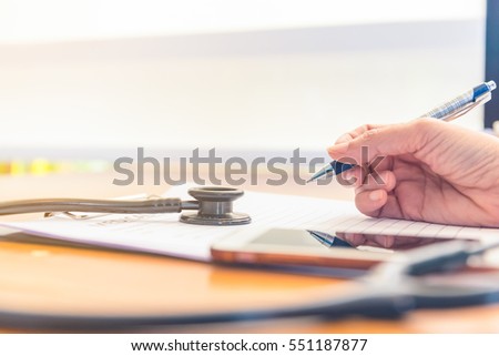  Doctor working at wooden desk in clinic