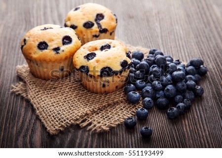 muffin with blueberries on a wooden table. fresh berries and sweet pastries on the board Royalty-Free Stock Photo #551193499