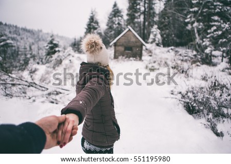 Young couple winter adventures.winter ,Snow isolated.Hold each other hands,girl and her boyfriend walking in forest