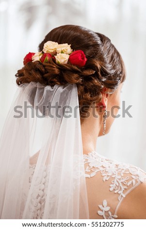 Beautiful bride's hairstyle with lively red flowers
