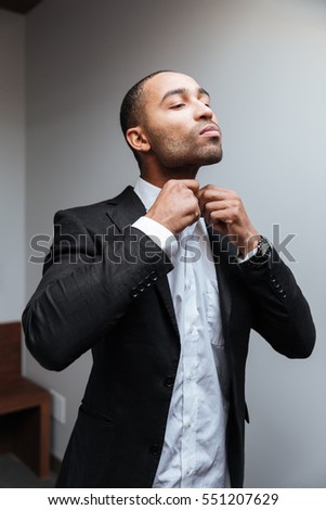 Vertical image of African man in suit buttons shirt in hotel