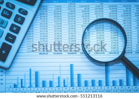 Spreadsheet bank accounts accounting with calculator and magnifying glass. Concept for financial fraud investigation, audit and analysis. Royalty-Free Stock Photo #551213116