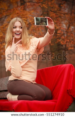 Photography people concept. Blonde young girl taking a selfie. Beautiful woman takes picture with mobile phone.