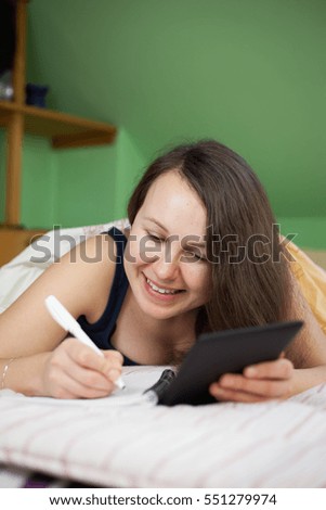 Pretty young brunette woman studying and preparing for her important exams with tablet