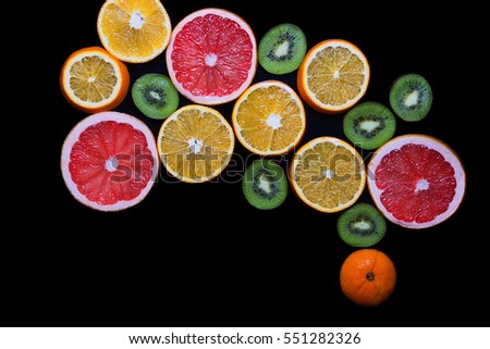 Slices of grapefruit, kiwi and orange arranged in the form of US map. Fruits on a black background closeup