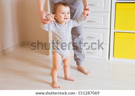 baby steps with the help of his mother Royalty-Free Stock Photo #551287069